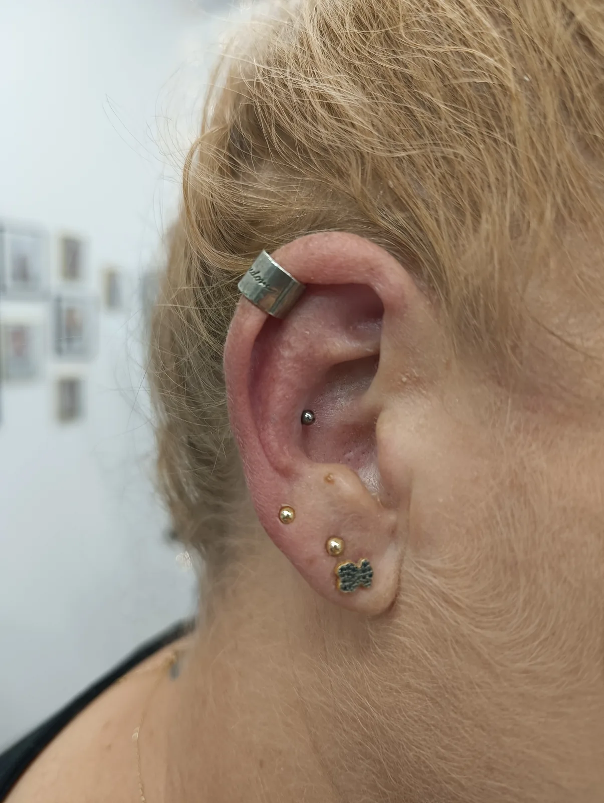 Kompozycja ucha z przekłuciem conch i złotą biżuterią